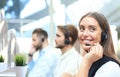 Portrait of call center worker accompanied by her team. Smiling customer support operator at work Royalty Free Stock Photo