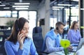 Portrait of call center worker accompanied by her team. Smiling customer support operator at work Royalty Free Stock Photo