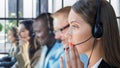 Portrait of call center worker accompanied by her team. Smiling customer support operator at work Royalty Free Stock Photo