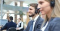 Portrait of call center worker accompanied by his team. Smiling customer support operator at work Royalty Free Stock Photo