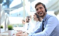 Portrait of call center worker accompanied by his team. Smiling customer support operator at work Royalty Free Stock Photo