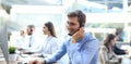 Portrait of call center worker accompanied by his team. Smiling customer support operator at work. Royalty Free Stock Photo
