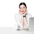 Portrait of calm attractive brunette businesswoman with makeup in white shirt sitting with laptop, touching her face and looking Royalty Free Stock Photo