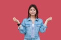 Portrait of calm beautiful brunette young woman with makeup in denim casual style standing with raised arms and doing meditating Royalty Free Stock Photo