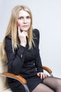 Portrait of Calm Blond Woman Sitting in Light Chair. Studio Shot