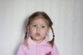 Portrait of calm child without emotions looking aside on white background