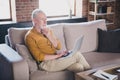 Portrait of calm concentrated person sit on sofa hold laptop hand on chin look interested far away home indoors Royalty Free Stock Photo