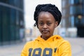 Calm confident fashionable young black lady, beautiful trendy african american woman with dreadlocks in yellow clothes Royalty Free Stock Photo