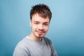 Portrait of calm positive young brunette man looking at camera with friendly expression. indoor studio shot isolated on blue Royalty Free Stock Photo