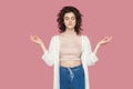 Portrait of calm relaxed beautiful brunette young woman with curly hairstyle in casual style standing in yoga pose raised arms, Royalty Free Stock Photo