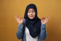 Portrait of calm relaxed beautiful young Asian muslim woman wearing hijab in casual style standing in yoga pose raised arms Royalty Free Stock Photo