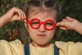 Portrait of capricious funny little girl in red fake glasses Royalty Free Stock Photo