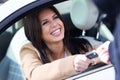 Car rental agency employee giving car keys to beautiful young woman.