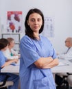 Portrait of cardiologist woman with stethoscope looking into camera wearing medical uniform