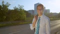 PORTRAIT: Carefree businessman casually walking down the street on a sunny day.