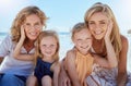 Portrait of a carefree family relaxing and bonding on the beach. Two cheerful little girls having fun with their mother Royalty Free Stock Photo