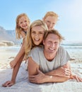 Portrait of a carefree family relaxing and bonding on the beach. Two cheerful little girls having fun with their parents Royalty Free Stock Photo