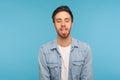 Portrait of carefree happy man in worker denim shirt standing with closed eyes, showing tongue out having fun Royalty Free Stock Photo