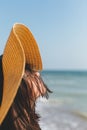 Portrait of carefree happy woman with windy hair in hat relaxing on sunny beach at sea. Summer vacation. Stylish calm young female Royalty Free Stock Photo