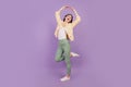 Portrait of carefree inspired girl dance raise hands on purple background
