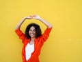 Portrait of a carefree smiling African American young girl on a yellow background