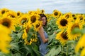 Portrait of a carefree woman in sunflowers field. Beautiful young caucasian woman posing outdoor at sunset Royalty Free Stock Photo