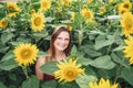 Portrait of carefree young woman smiling amidst sunflower plants at farm