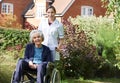 Portrait Of Carer Pushing Senior Woman In Wheelchair Royalty Free Stock Photo