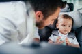 Portrait of caring young father and baby boy enjoying car transportation with child seat Royalty Free Stock Photo