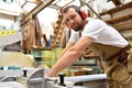 portrait of a carpenter in work clothes and hearing protection in the workshop of a carpenter's shop Royalty Free Stock Photo