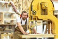 portrait of a carpenter in work clothes and hearing protection in the workshop of a carpenter\'s shop Royalty Free Stock Photo