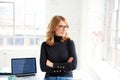 Portrait of casual businesswoman deep in thought while standing in the office Royalty Free Stock Photo