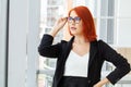 Portrait of a casual businesswoman with short red hair in a modern house. Royalty Free Stock Photo