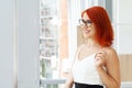 Portrait of a casual businesswoman with short red hair in a modern house. Royalty Free Stock Photo