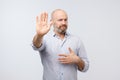 European man showing stop sign over gray background Royalty Free Stock Photo