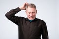 Portrait of casual mature man in black shirt thinking and looking puzzled Royalty Free Stock Photo