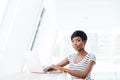 Portrait of a casual smiling african businesswoman using laptop computer Royalty Free Stock Photo