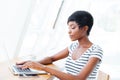 Portrait of a casual smiling african businesswoman using laptop computer Royalty Free Stock Photo