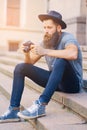 Street photographer sits on a step.