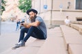 Street photographer sits on a step.