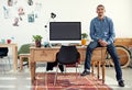 Time to design. Portrait of a casually-dressed young man sitting on his desk in an office. Royalty Free Stock Photo