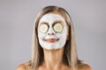 Aged woman with mask on face and cucumber on eyes Royalty Free Stock Photo