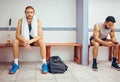 Portrait of a caucasian athlete sitting in a locker room. Two men sitting in a gym locker room together. Serious player Royalty Free Stock Photo