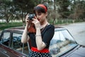 Portrait of Caucasian beautiful young girl in black vintage dress posing with vintage camera in hands Royalty Free Stock Photo