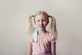 Portrait of Caucasian blonde girl taking off sanitary face mask. Preschool child with protective mask on ear. End finish of covid-