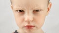 Portrait caucasian boy 4 years old, angry child expresses emotions of discontent or anger looks at camera on white Royalty Free Stock Photo