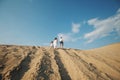 Portrait of caucasian family with baby in white clothes are standing on sands dune. Pregnant mpther. Newborn Royalty Free Stock Photo