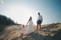 Portrait of caucasian family with baby in white clothes are standing on sands dune. Pregnant mpther. Newborn Royalty Free Stock Photo