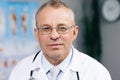 Portrait of Caucasian Family Medical Doctor in Glasses is in Health Clinic. Successful Physician in White Lab Coat Looks Royalty Free Stock Photo