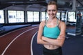 Female athletic standing with arms crossed in fitness center